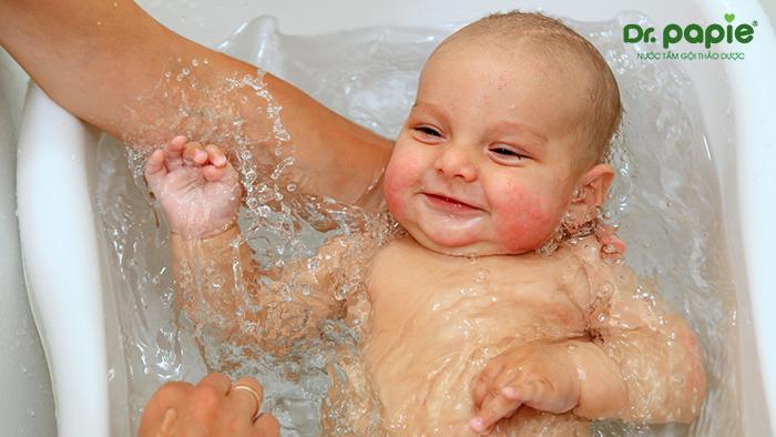 Tráng người bé sau khi tắm nước lá